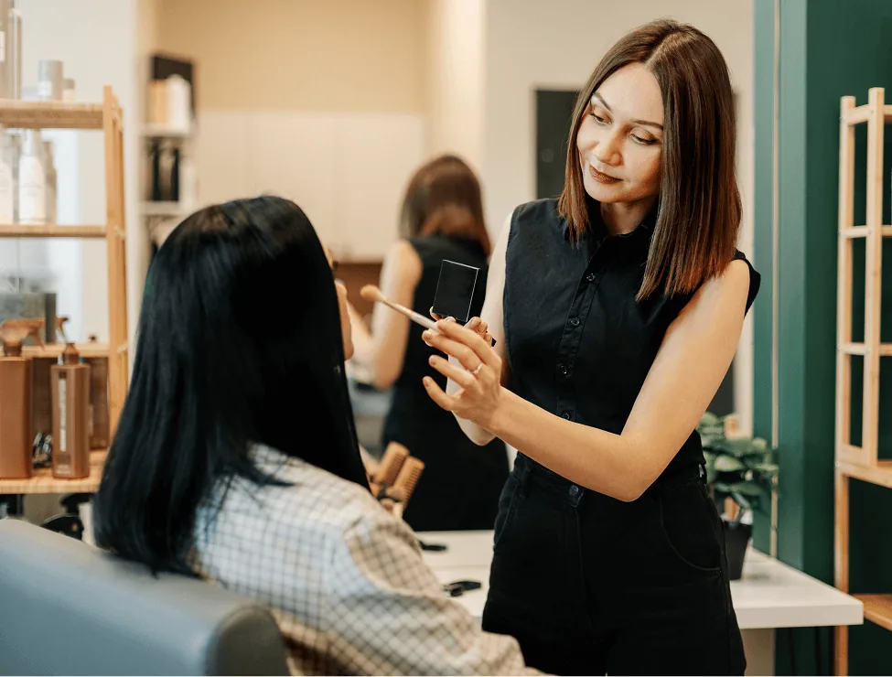 Stylist showing something to a client in a Quality Stylz suite